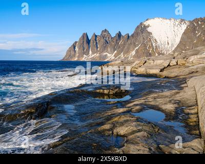 Küstenlandschaft bei Tungeneset und den Gipfeln Okshornan (Devils Teeth). Die Insel Senja im Winter im Norden Norwegens. Stockfoto