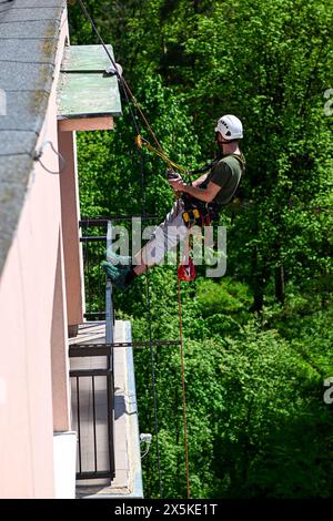 Hochhausarbeiten in einem Wohnhaus. Ein Bauarbeiter überprüft den Zustand eines Wohngebäudes für den geplanten Wiederaufbau mit Hilfe von Climbi Stockfoto