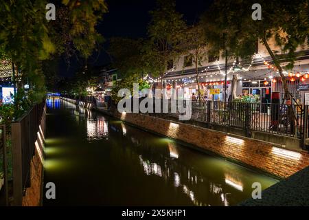 Restaurants und andere Geschäfte an einem kleinen Kanal im Chinatown in Bangkok, Thailand, abends. Stockfoto