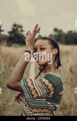 Nigeria, Bundesstaat Delta, Porträt einer Frau in gemustertem Kleid, die im Feld steht Stockfoto