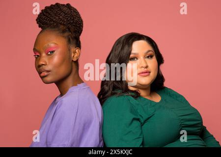 Studio-Porträt von zwei Frauen Rücken an Rücken Stockfoto