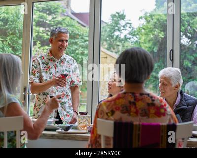 Familie Toasten mit Rotwein am Esstisch Stockfoto