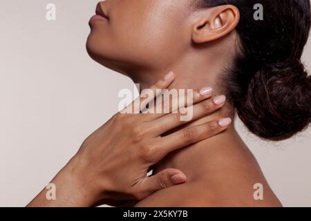 Junge Frau Hals berühren Stockfoto