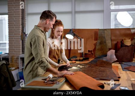 Frau und Mann überprüfen die Oberfläche des natürlichen Materials in der Werkstatt Nahaufnahme Seitenaufnahme, Kopierraum Stockfoto