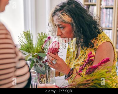 Frau riecht Blumen im Blumenstrauß Stockfoto