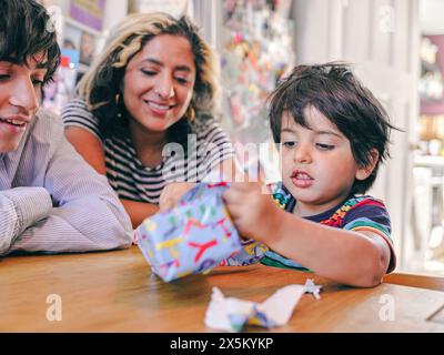 Junge Eröffnung Geburtstagsgeschenk mit Familie Stockfoto