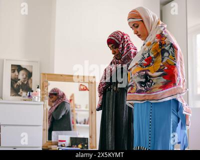 Muslimische Frau mit Teenager-Tochter, die zu Hause betet Stockfoto