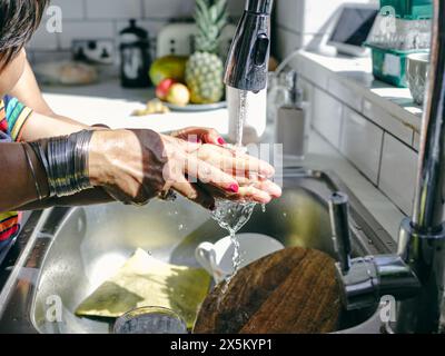 Nahaufnahme von Mutter und Sohn beim Händewaschen in Küchenspüle Stockfoto