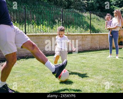 Vater mit Sohn spielt Fußball im Hinterhof Stockfoto