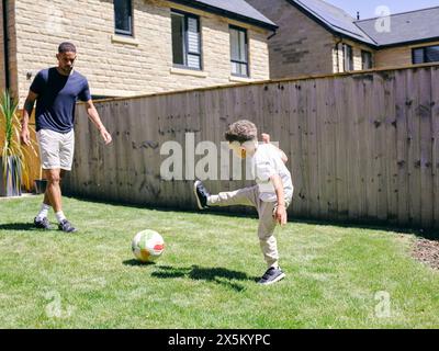 Vater mit Sohn spielt Fußball im Hinterhof Stockfoto