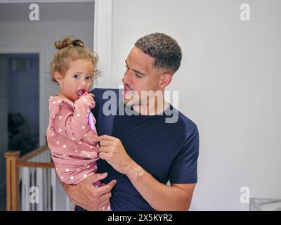 Vater helfende Tochter Zähneputzen im Bad Stockfoto