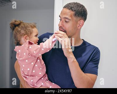 Vater helfende Tochter Zähneputzen im Bad Stockfoto