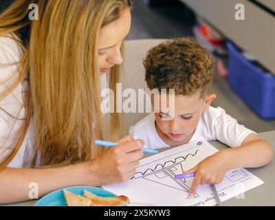 Mutter hilft dem Sohn bei Hausaufgaben zu Hause Stockfoto