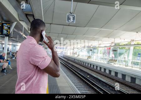 Mann, der telefoniert, während er auf dem Bahnsteig steht Stockfoto