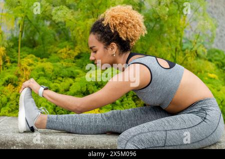 Sportliche junge Frau dehnt sich aus Stockfoto