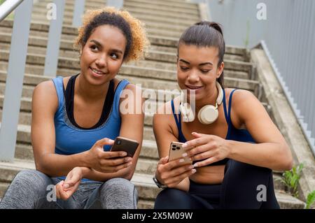 Sportliche Freundinnen mit Handys Stockfoto