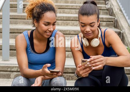 Sportliche Freundinnen mit Handys Stockfoto