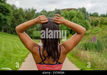 Rückansicht einer Frau, die vor dem Training Haare bindet Stockfoto