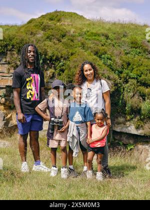 Außenporträt einer Familie mit drei Kindern, die in der Natur stehen Stockfoto