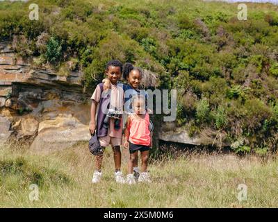 Drei Geschwister stehen zusammen in der Natur Stockfoto