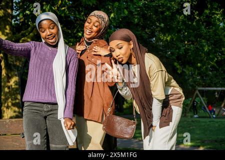 Großbritannien, London, Porträt von drei jungen Frauen, die Hijabs im Park tragen Stockfoto