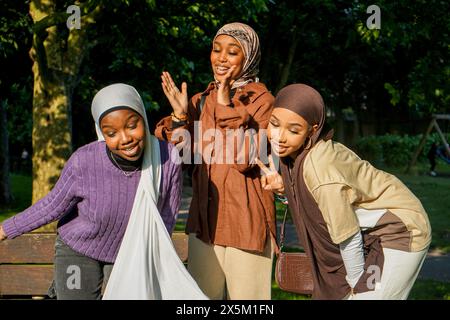 Großbritannien, London, Porträt von drei jungen Frauen, die Hijabs im Park tragen Stockfoto