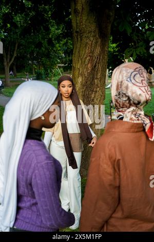 Großbritannien, London, drei junge Frauen in Hijabs, die im Park reden Stockfoto