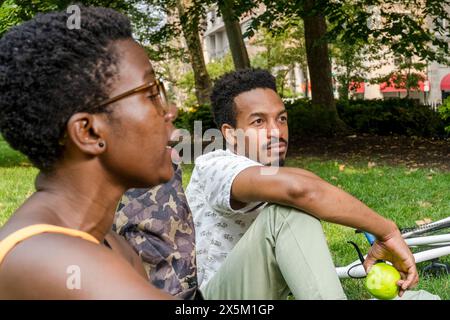 USA, Freunde, die auf dem Rasen im Park sitzen Stockfoto