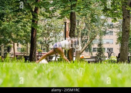 USA, Junge Frau, die Yoga auf dem Rasen im Park praktiziert Stockfoto