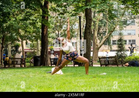 USA, Junge Frau, die Yoga auf dem Rasen im Park praktiziert Stockfoto