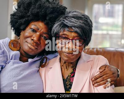 Portrait reife Frau, die ältere Mutter auf dem Sofa umschließt Stockfoto