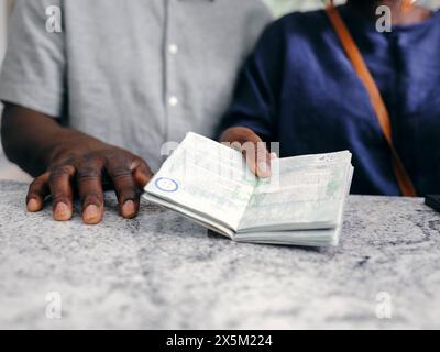Großbritannien, Nahaufnahme eines älteren Paares mit Reisepass an der Hotelrezeption Stockfoto