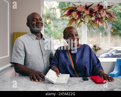 Großbritannien, Nahaufnahme eines älteren Paares mit Reisepass an der Hotelrezeption Stockfoto