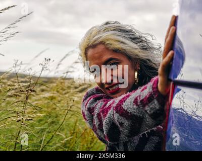 Frau schiebt kaputtes Auto Stockfoto