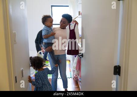 Mutter und Töchter pflücken Kleidung Stockfoto