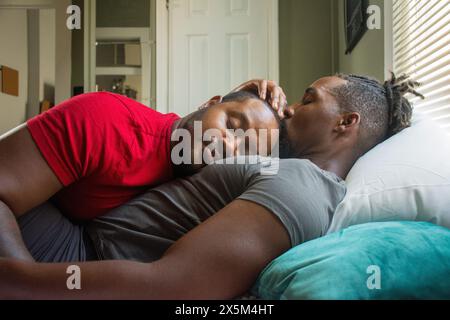 Männliches Paar kuschelt im Bett Stockfoto