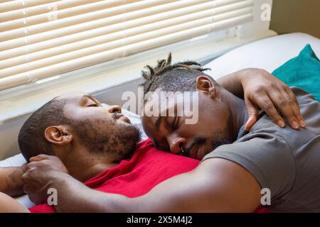 Männliches Paar kuschelt im Bett Stockfoto