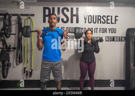 Frau und Mann mit Beinprothetik im Fitnessstudio Stockfoto