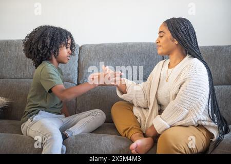 Mutter spielt mit Sohn auf dem Sofa Stockfoto