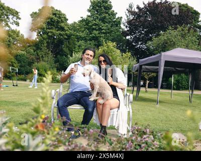 Porträt von reifem Paar und Hund im Hinterhof Stockfoto