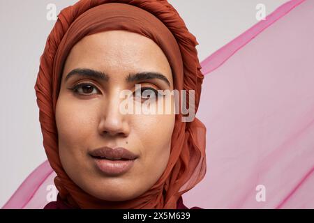 Studio-Porträt einer lächelnden Frau, die Brownhijab trägt Stockfoto