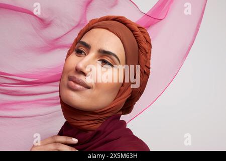 Studio-Porträt einer lächelnden Frau, die Brownhijab trägt Stockfoto