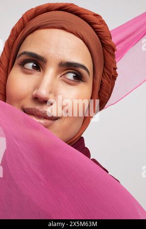 Studio-Porträt einer lächelnden Frau, die Brownhijab trägt Stockfoto