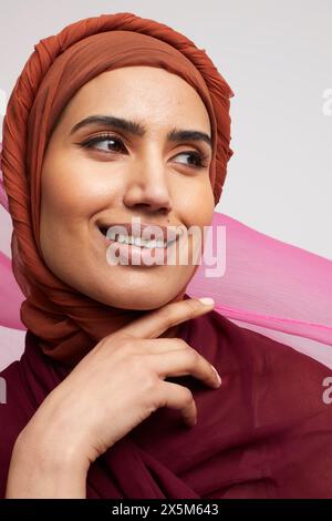 Studio-Porträt einer lächelnden Frau, die Brownhijab trägt Stockfoto