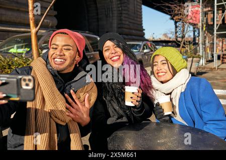 USA, New York City, lächelnde Freunde machen Selfie am Straßencafé-Tisch Stockfoto