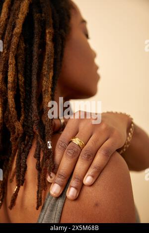 Nahaufnahme einer Frau mit Dreadlocks, die den Arm berühren Stockfoto