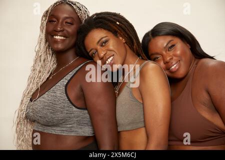 Studio-Porträt von drei lächelnden Frauen in Sportbekleidung Stockfoto