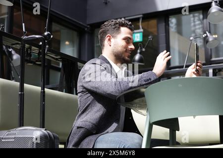Lächelnder Geschäftsmann, der Videoanruf am Telefon hat Stockfoto