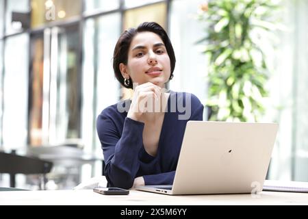 Porträt der jungen Geschäftsfrau mit Laptop im Büro Stockfoto