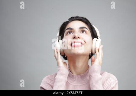 Junge Frau Hören von Musik über Kopfhörer Stockfoto
